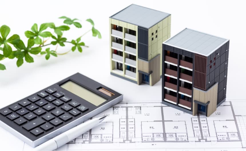 マンションの模型と電卓とボールペン